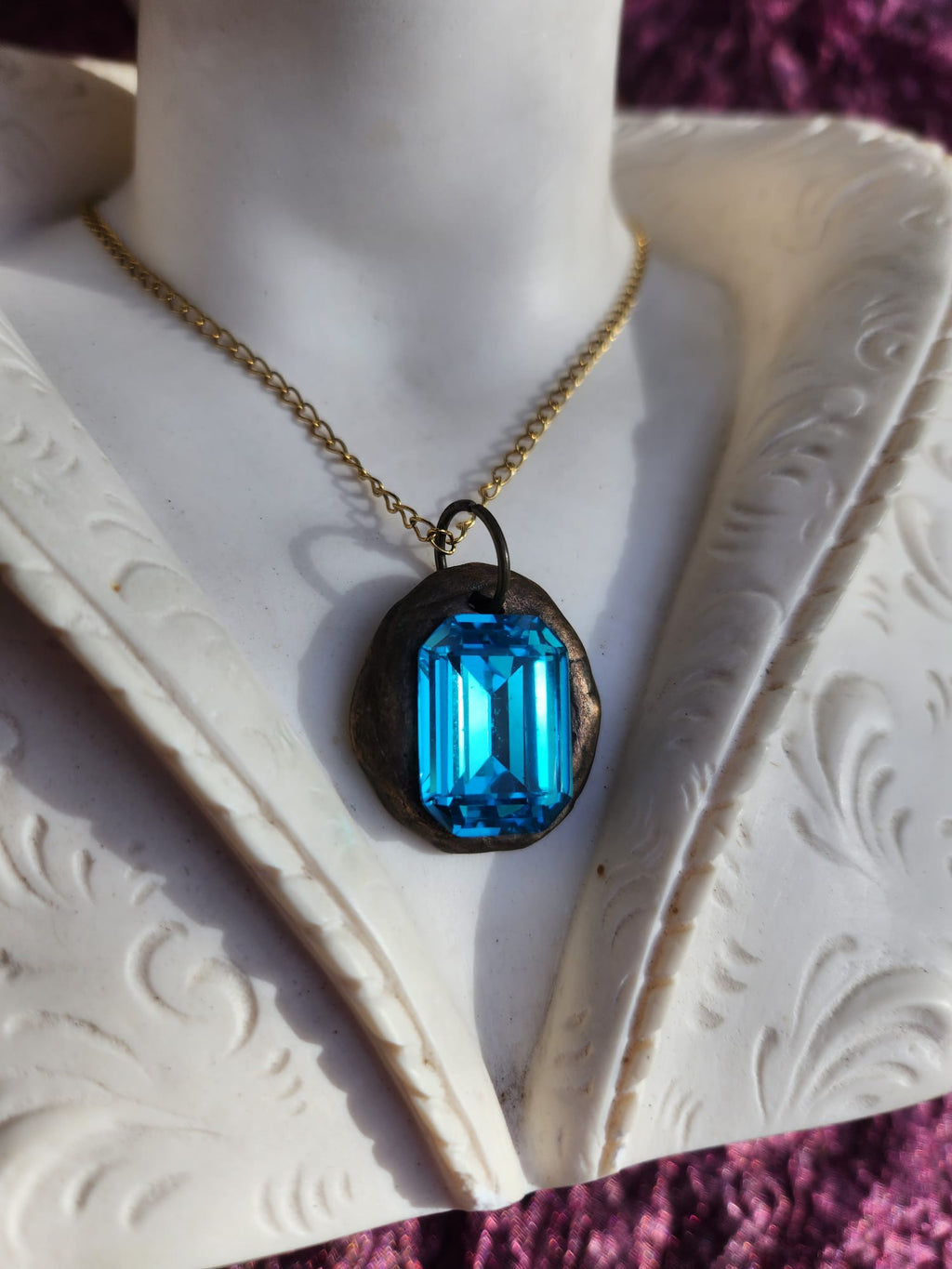 Colgante de bronce hecho a mano con cristal azul.