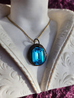 Colgante de bronce hecho a mano con cristal azul.