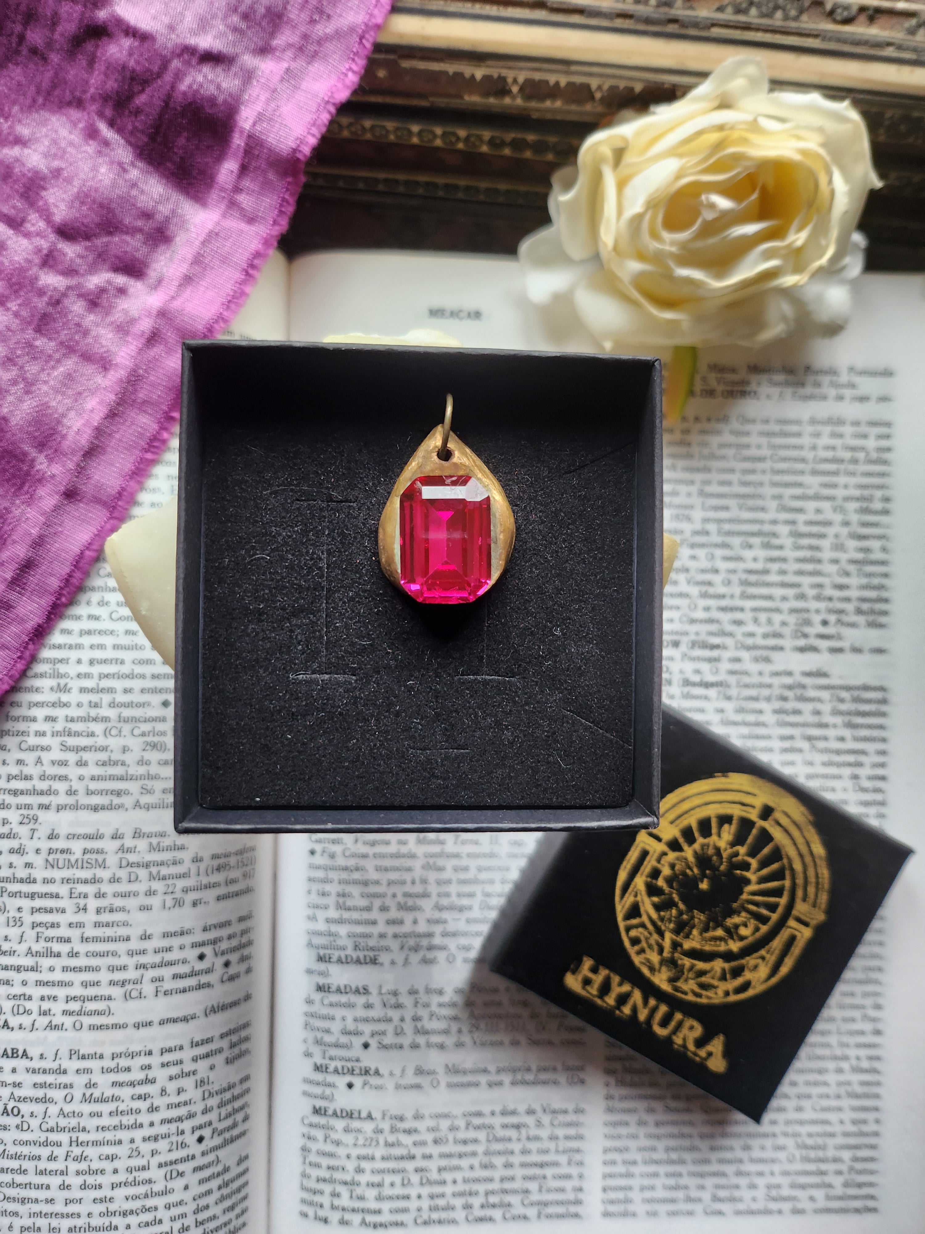 Colgante de bronce hecho a mano con cristal fucsia.